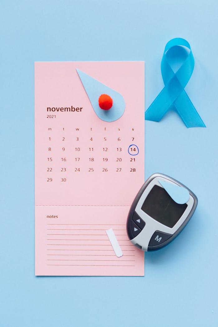 services-04 Pink calendar for November with blue ribbon and glucose meter symbolizing diabetes awareness.